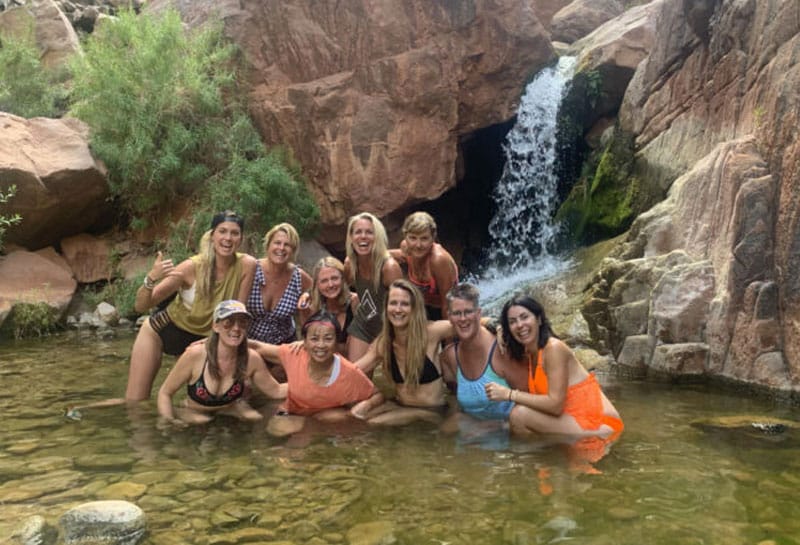 people sitting in waterfall pool in Grand Canyon with Sara Schulting Kranz